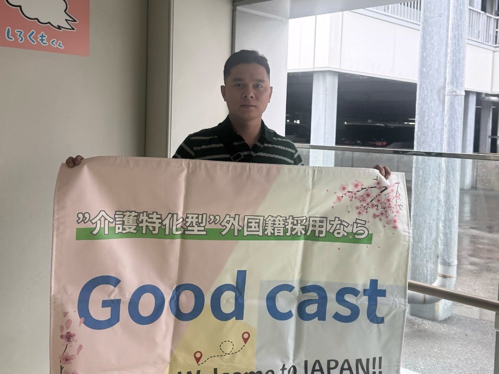 Welcome to JAPANの横断幕を持つスタッフ